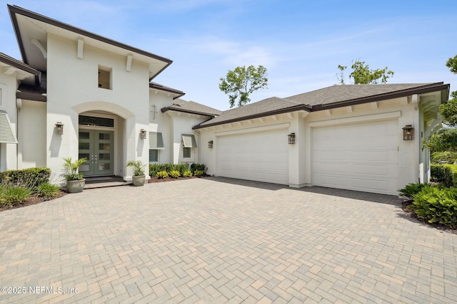 1332 N Loop Pkwy, Saint Augustine, FL 32095 - view of front facade featuring french doors, decorative driveway, an attached garage, and stucco siding