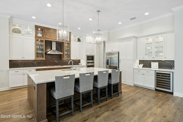 1332 N Loop Pkwy, Saint Augustine, FL 32095 - kitchen featuring appliances with stainless steel finishes, wall chimney range hood, wine cooler, a chandelier, and a kitchen island with sink