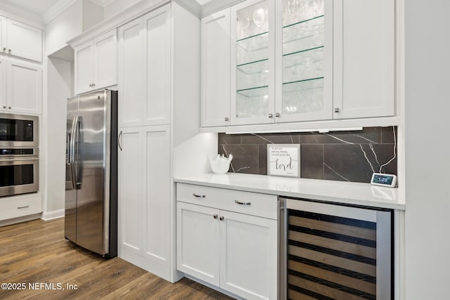 1332 N Loop Pkwy, Saint Augustine, FL 32095 - bar area featuring wine cooler, stainless steel appliances, decorative backsplash, ornamental molding, and wood finished floors