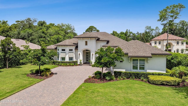 1332 N Loop Pkwy, Saint Augustine, FL 32095 - view of front of home with stucco siding, a front lawn, decorative driveway, and a shingled roof