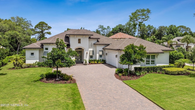 1332 N Loop Pkwy, Saint Augustine, FL 32095 - french country style house with stucco siding, an attached garage, decorative driveway, and a front lawn