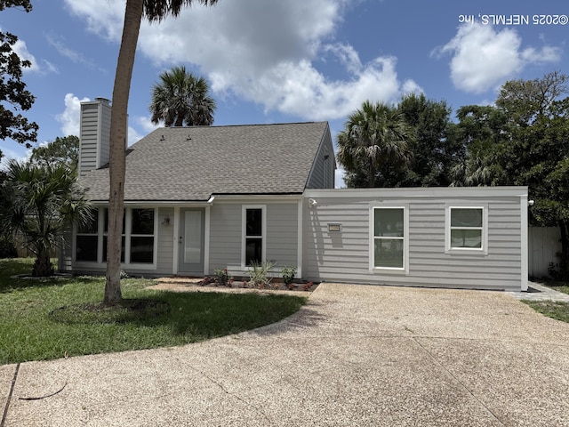 2406 Oakview Dr, Jacksonville, FL 32246 - back of property with concrete driveway, a chimney, a yard, and a shingled roof
