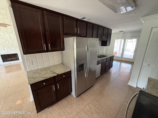 2406 Oakview Dr, Jacksonville, FL 32246 - kitchen with stainless steel refrigerator with ice dispenser, decorative backsplash, light tile patterned floors, a sink, and dark brown cabinets