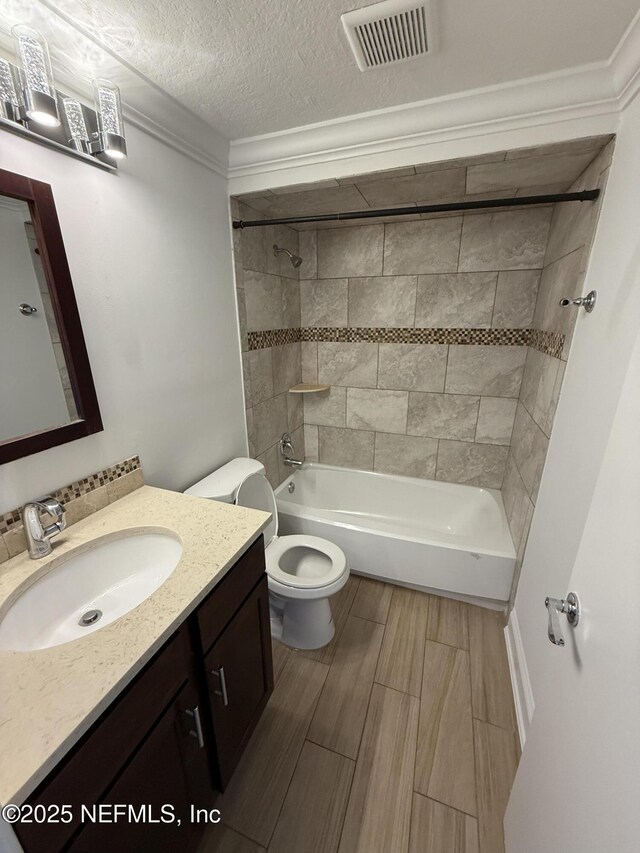 2406 Oakview Dr, Jacksonville, FL 32246 - full bath featuring vanity, toilet, washtub / shower combination, wood finish floors, and a textured ceiling