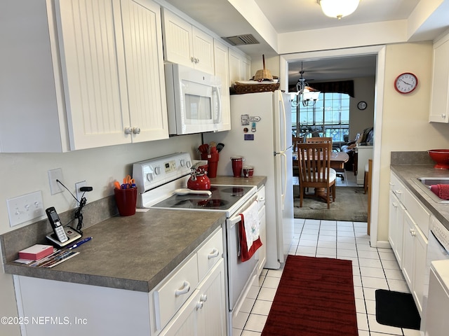 1830 Sevilla Blvd Unit 207, Atlantic Beach, FL 32233 - kitchen featuring white appliances, light tile patterned floors, dark countertops, and white cabinets