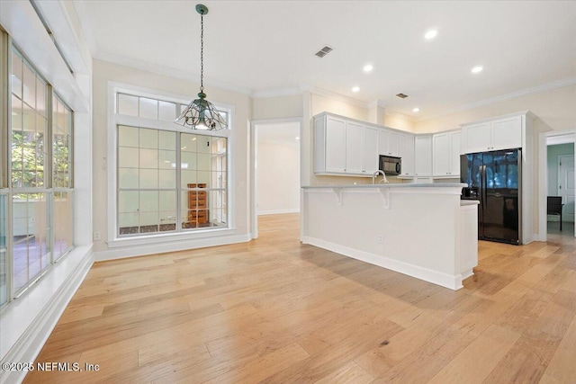 2227 Barefoot Trce, Atlantic Beach, FL 32233 - kitchen with black appliances, crown molding, light wood-style flooring, light countertops, and hanging light fixtures