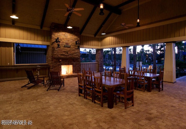 800 Marjories Way, Saint Augustine, FL 32092 - dining space with a ceiling fan, high vaulted ceiling, an outdoor stone fireplace, beamed ceiling, and wood walls