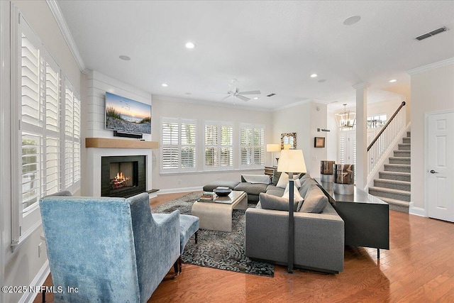 321 5th St, Atlantic Beach, FL 32233 - living room featuring a lit fireplace, a ceiling fan, ornamental molding, baseboards, and stairs