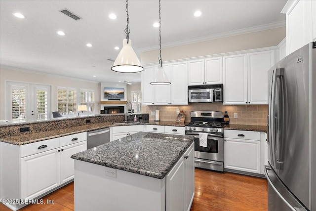 321 5th St, Atlantic Beach, FL 32233 - kitchen featuring stainless steel appliances, a sink, crown molding, a peninsula, and plenty of natural light