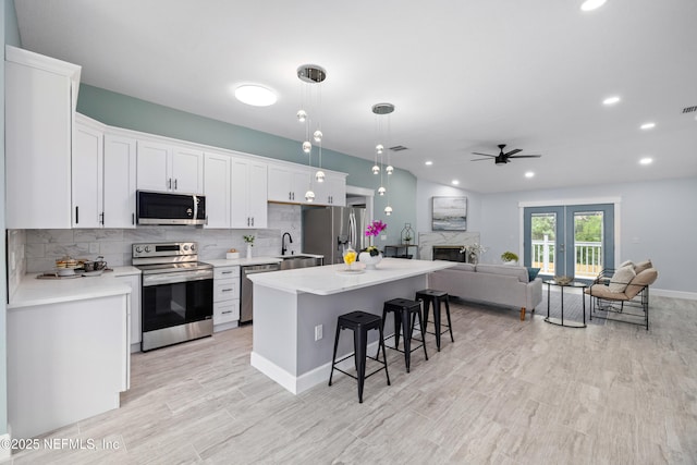 3064 Hickory Glen Dr, Jacksonville, FL 32065 - kitchen with appliances with stainless steel finishes, ceiling fan, a kitchen bar, white cabinetry, and recessed lighting