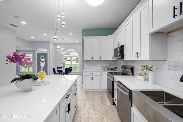 3064 Hickory Glen Dr, Jacksonville, FL 32065 - kitchen featuring stainless steel appliances, white cabinetry, hanging light fixtures, backsplash, and recessed lighting