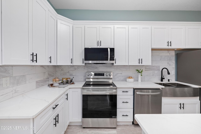 3064 Hickory Glen Dr, Jacksonville, FL 32065 - kitchen featuring stainless steel appliances, a sink, backsplash, and white cabinetry