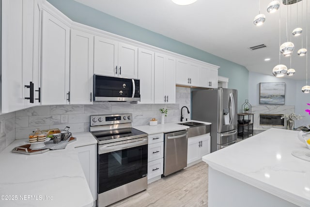 3064 Hickory Glen Dr, Jacksonville, FL 32065 - kitchen with appliances with stainless steel finishes, white cabinets, tasteful backsplash, and light wood-style floors