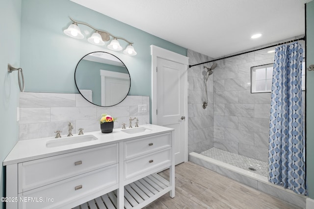 3064 Hickory Glen Dr, Jacksonville, FL 32065 - bathroom featuring a tile shower, double vanity, and wood finished floors