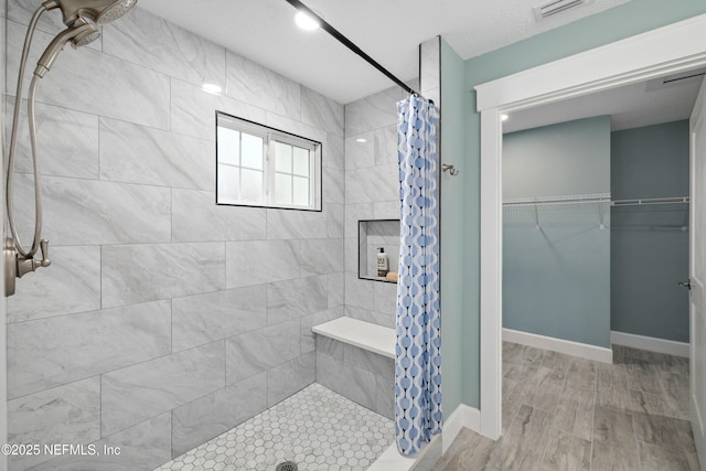 3064 Hickory Glen Dr, Jacksonville, FL 32065 - bathroom featuring a stall shower, wood finished floors, a spacious closet, and baseboards