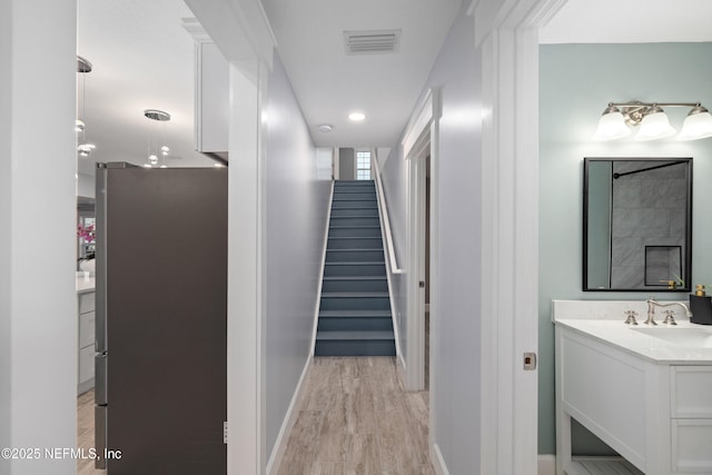 3064 Hickory Glen Dr, Jacksonville, FL 32065 - corridor with a sink, stairway, light wood-style flooring, baseboards, and recessed lighting