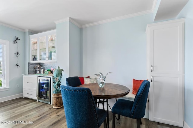 525 3rd St S Unit 513, Jacksonville Beach, FL 32250 - dining space featuring wine cooler, a bar, crown molding, and light wood finished floors