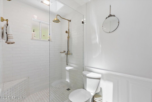5265 State Rd 13 N, Saint Augustine, FL 32092 - bathroom featuring a tile shower, wainscoting, and a decorative wall