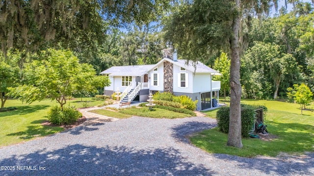 5265 State Rd 13 N, Saint Augustine, FL 32092 - view of front of home with a chimney, driveway, a front lawn, and view of wooded area