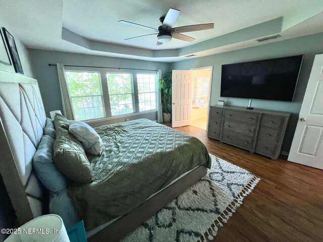 11110 Castlemain Cir S, Jacksonville, FL 32256 - bedroom with wood finished floors, a tray ceiling, a ceiling fan, and ensuite bathroom