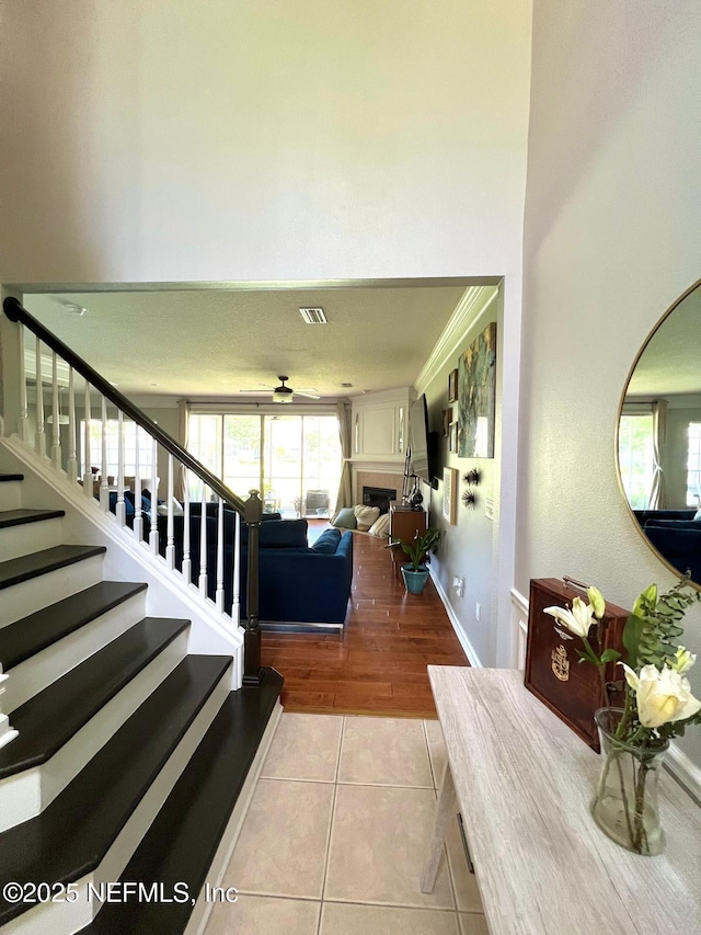 11110 Castlemain Cir S, Jacksonville, FL 32256 - entrance foyer with tile patterned flooring, stairs, ceiling fan, and a fireplace