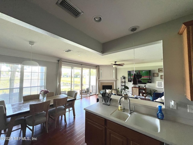 11110 Castlemain Cir S, Jacksonville, FL 32256 - kitchen with open floor plan, light countertops, dark wood-type flooring, a tile fireplace, and hanging light fixtures
