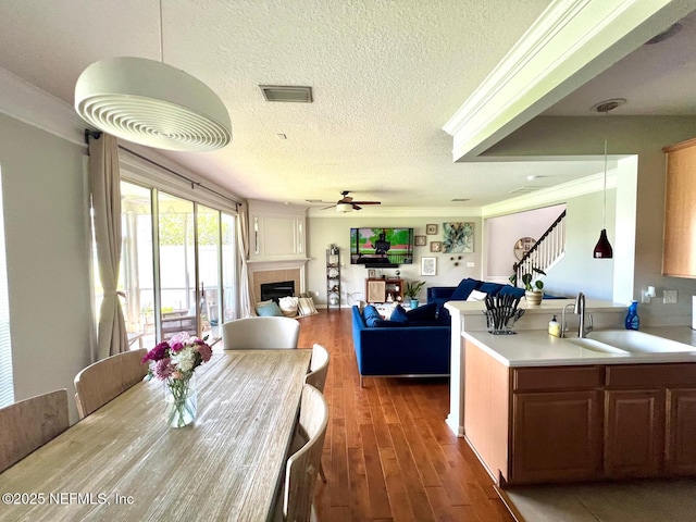 11110 Castlemain Cir S, Jacksonville, FL 32256 - dining area with ceiling fan, a tiled fireplace, wood finished floors, a textured ceiling, and stairway