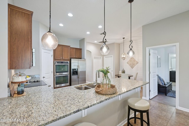 1804 Eagle Crest Dr, Fleming Island, FL 32003 - kitchen featuring appliances with stainless steel finishes, a peninsula, a breakfast bar, brown cabinets, and recessed lighting