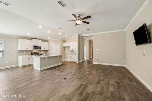 1382 Parkland Trl, Saint Augustine, FL 32095 - unfurnished living room with a ceiling fan, crown molding, wood finished floors, recessed lighting, and a textured ceiling