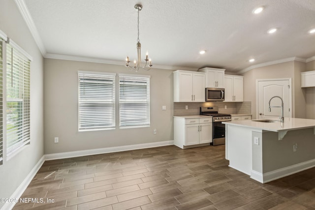 1382 Parkland Trl, Saint Augustine, FL 32095 - kitchen with stainless steel appliances, a sink, a chandelier, crown molding, and light countertops