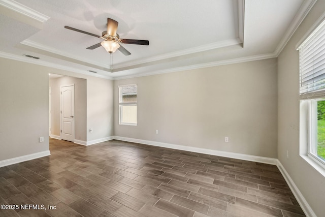 1382 Parkland Trl, Saint Augustine, FL 32095 - spare room featuring a tray ceiling, plenty of natural light, ceiling fan, ornamental molding, and wood finish floors