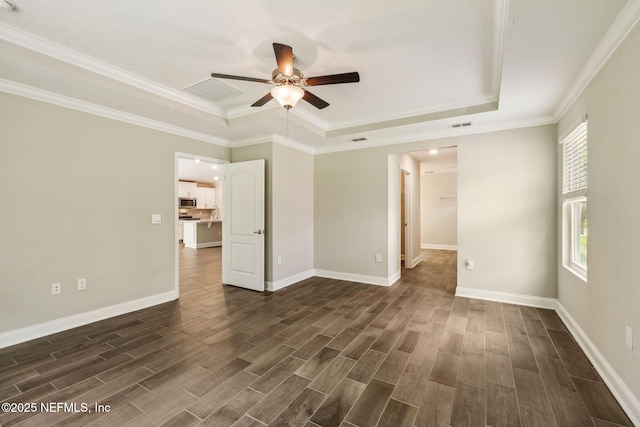 1382 Parkland Trl, Saint Augustine, FL 32095 - spare room featuring a tray ceiling, ceiling fan, dark wood finished floors, ornamental molding, and baseboards