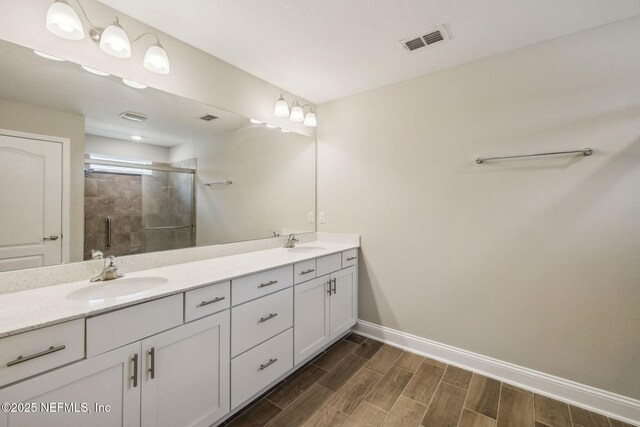 1382 Parkland Trl, Saint Augustine, FL 32095 - full bathroom with double vanity, a stall shower, baseboards, and wood finished floors