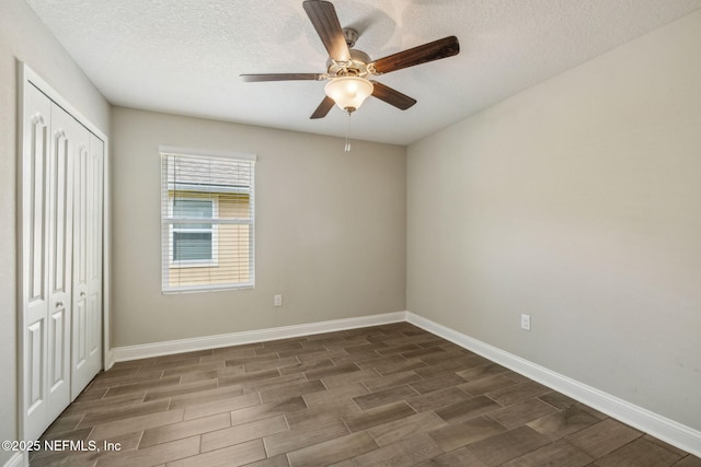 1382 Parkland Trl, Saint Augustine, FL 32095 - unfurnished bedroom with wood tiled floors, baseboards, a closet, a textured ceiling, and ceiling fan