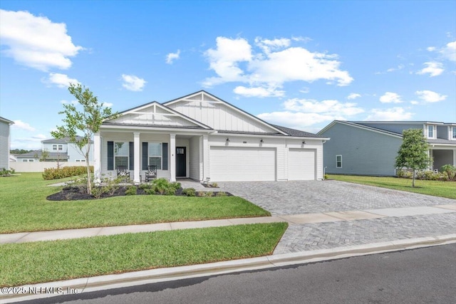 87 Tradesman Ln, Saint Johns, FL 32259 - view of front of property with a garage, board and batten siding, decorative driveway, a porch, and a front lawn