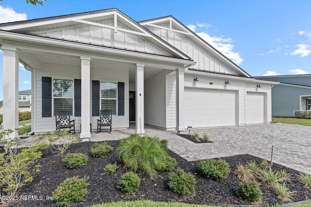 87 Tradesman Ln, Saint Johns, FL 32259 - view of front of property featuring covered porch, board and batten siding, a garage, and decorative driveway