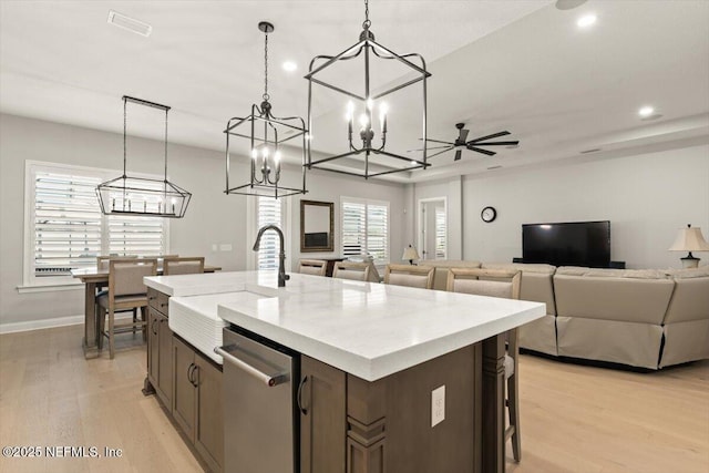 87 Tradesman Ln, Saint Johns, FL 32259 - kitchen with dishwasher, a chandelier, a center island with sink, open floor plan, and light wood-style floors