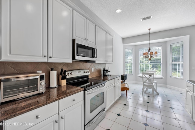 6542 Burnham Cir, Ponte Vedra Beach, FL 32082 - kitchen with appliances with stainless steel finishes, baseboards, decorative backsplash, white cabinets, and a chandelier