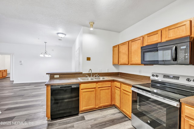 3641 Kirkpatrick Cir Unit 14-2, Jacksonville, FL 32210 - kitchen featuring black appliances, a sink, a peninsula, light wood-style floors, and a textured ceiling