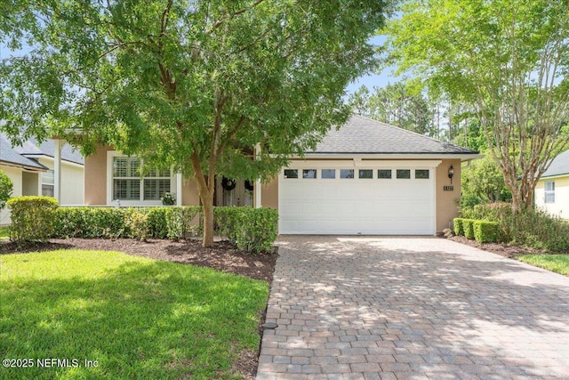 1327 Castle Pines Cir, Saint Augustine, FL 32092 - view of front of property with decorative driveway, stucco siding, an attached garage, roof with shingles, and a front lawn