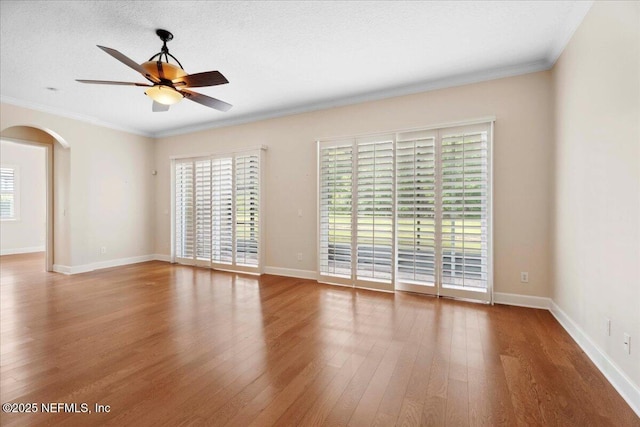 1327 Castle Pines Cir, Saint Augustine, FL 32092 - spare room with ornamental molding, arched walkways, a ceiling fan, wood finished floors, and plenty of natural light