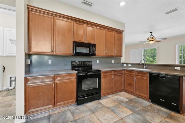 1327 Castle Pines Cir, Saint Augustine, FL 32092 - kitchen with black appliances, brown cabinets, a ceiling fan, and a peninsula