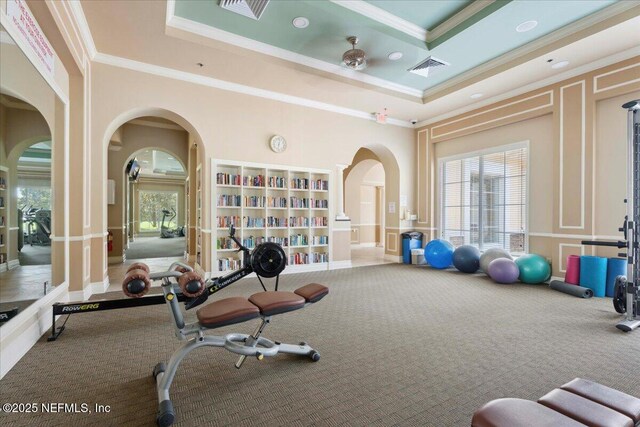 1327 Castle Pines Cir, Saint Augustine, FL 32092 - exercise room with arched walkways, carpet, crown molding, and a decorative wall