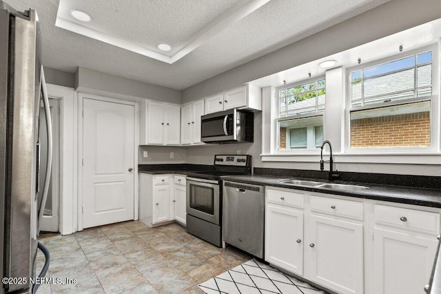 1032 Ingleside Ave, Jacksonville, FL 32205 - kitchen featuring stainless steel appliances, a textured ceiling, white cabinets, and dark countertops