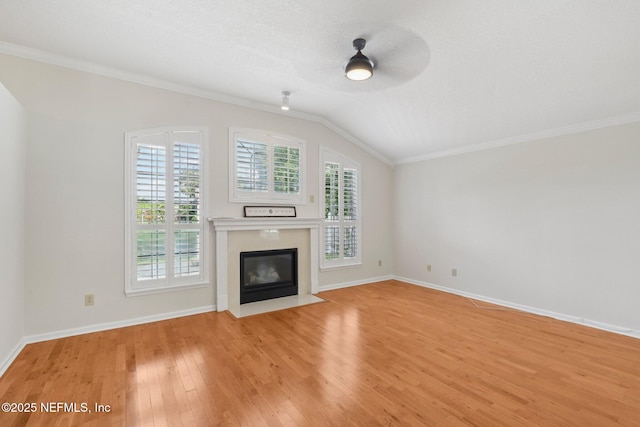 2002 Knottingham Trace Ln, Jacksonville, FL 32246 - unfurnished living room featuring light wood-style floors, a fireplace with flush hearth, a ceiling fan, ornamental molding, and vaulted ceiling