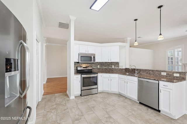 2002 Knottingham Trace Ln, Jacksonville, FL 32246 - kitchen featuring appliances with stainless steel finishes, ornamental molding, decorative backsplash, white cabinetry, and dark stone counters