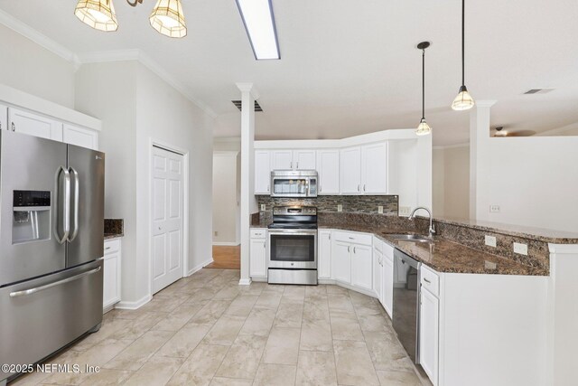 2002 Knottingham Trace Ln, Jacksonville, FL 32246 - kitchen with stainless steel appliances, crown molding, backsplash, white cabinetry, and dark stone countertops