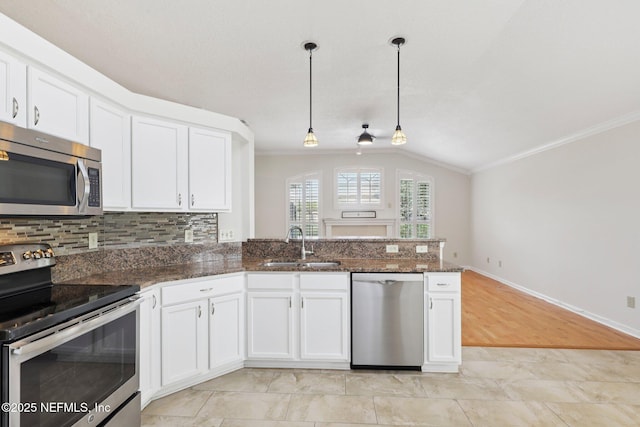 2002 Knottingham Trace Ln, Jacksonville, FL 32246 - kitchen with stainless steel appliances, crown molding, vaulted ceiling, white cabinets, and a peninsula