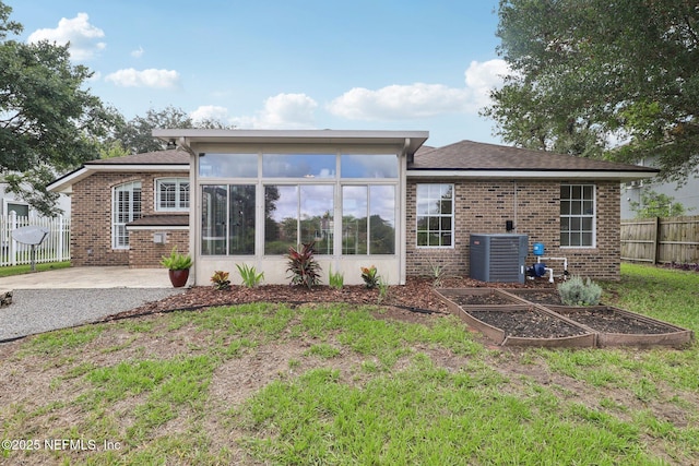 2002 Knottingham Trace Ln, Jacksonville, FL 32246 - rear view of property with a garden, a sunroom, brick siding, and a patio area