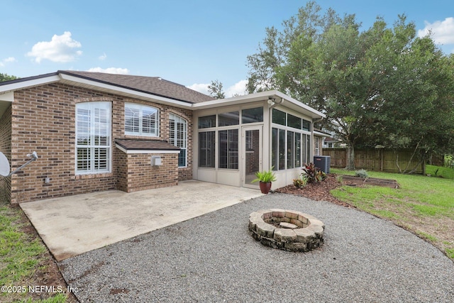 2002 Knottingham Trace Ln, Jacksonville, FL 32246 - rear view of property featuring a fire pit, a sunroom, a patio, and brick siding